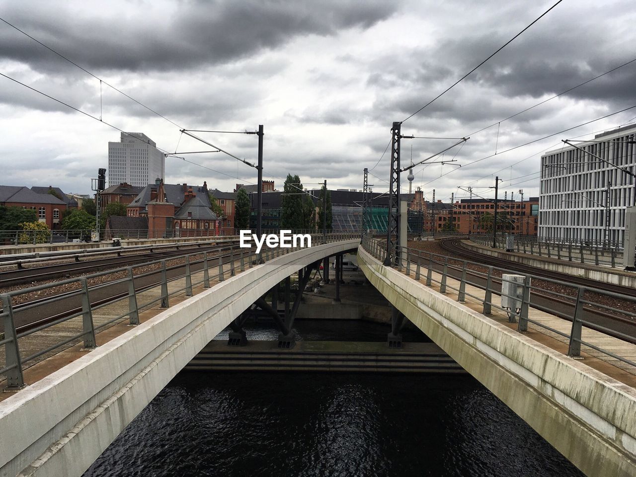 RAILROAD TRACKS BY CITY AGAINST SKY