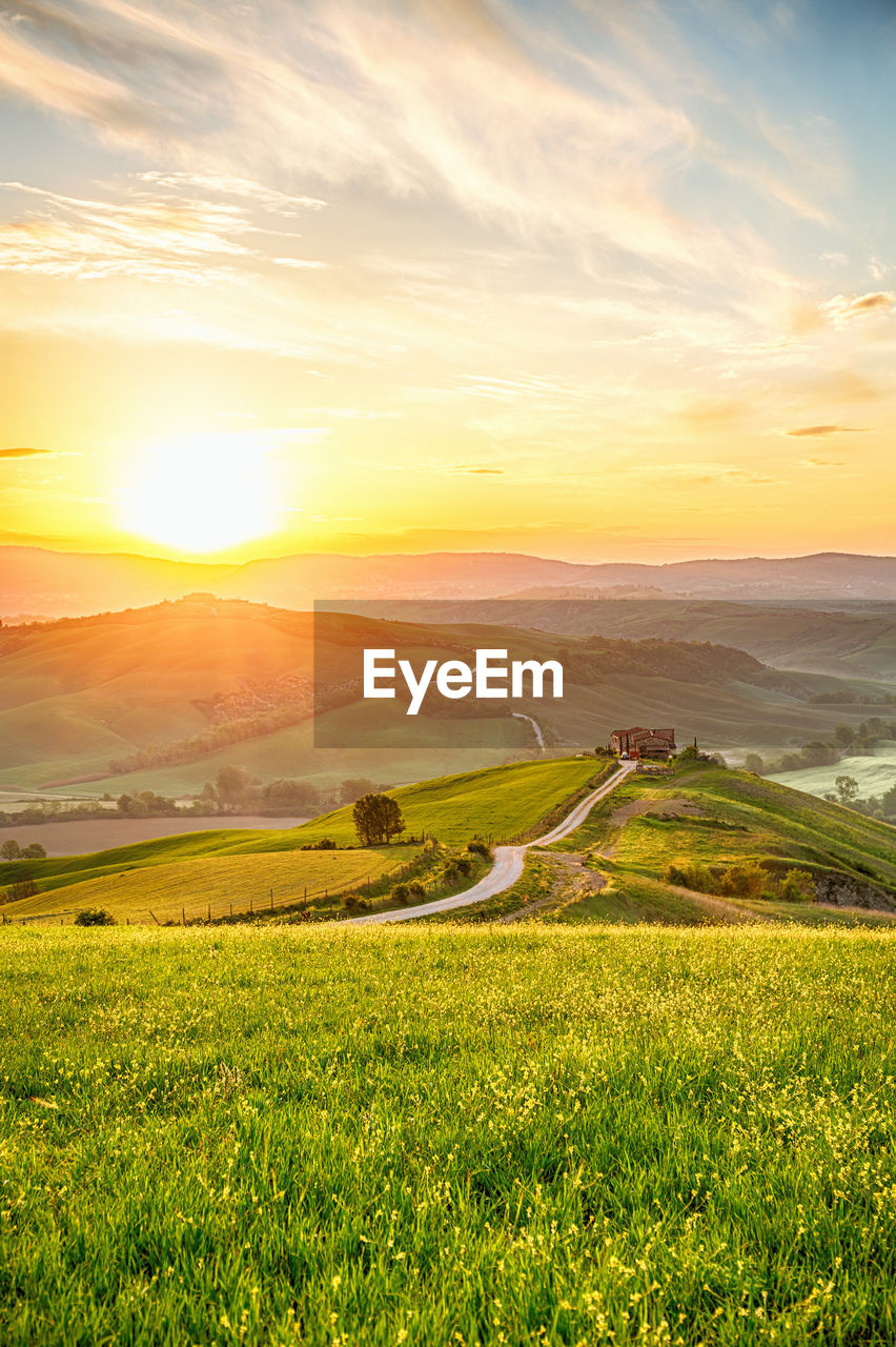 Sunrise over the hills of a rural landscape with a farm