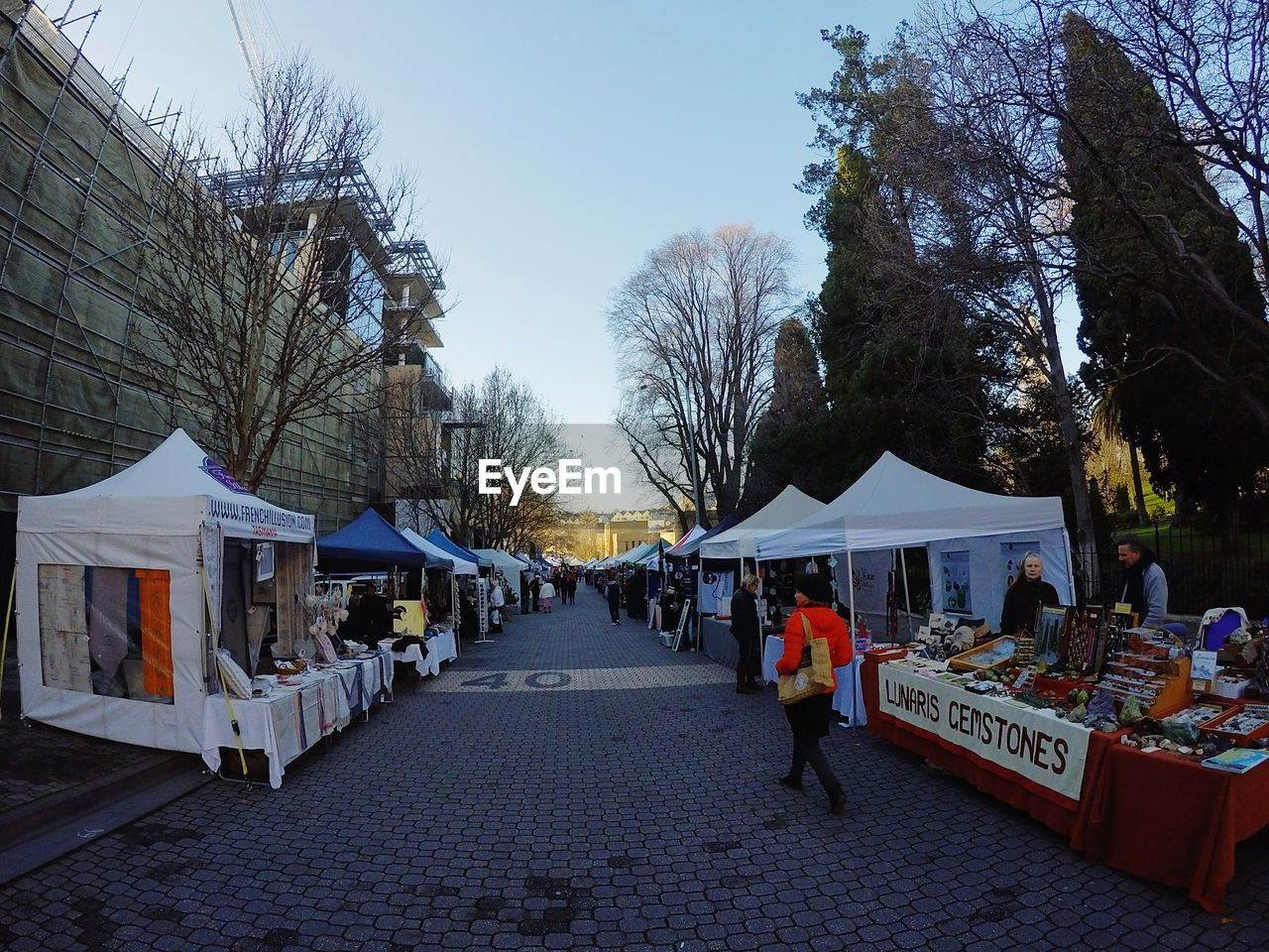 PANORAMIC VIEW OF PEOPLE ON STREET AGAINST SKY