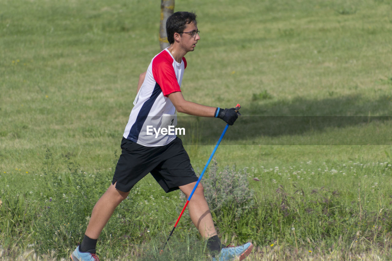 Side view of man playing on field