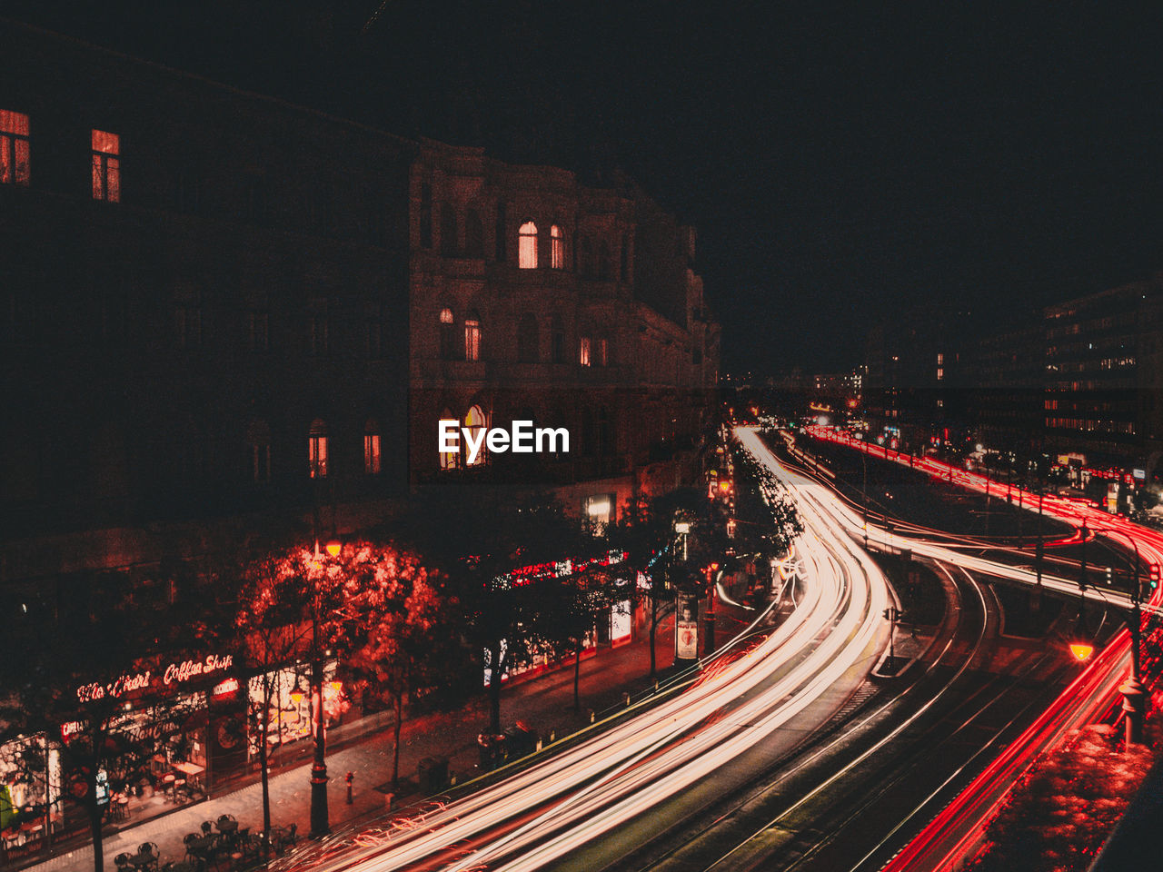 High angle view of light trails on road amidst buildings at night