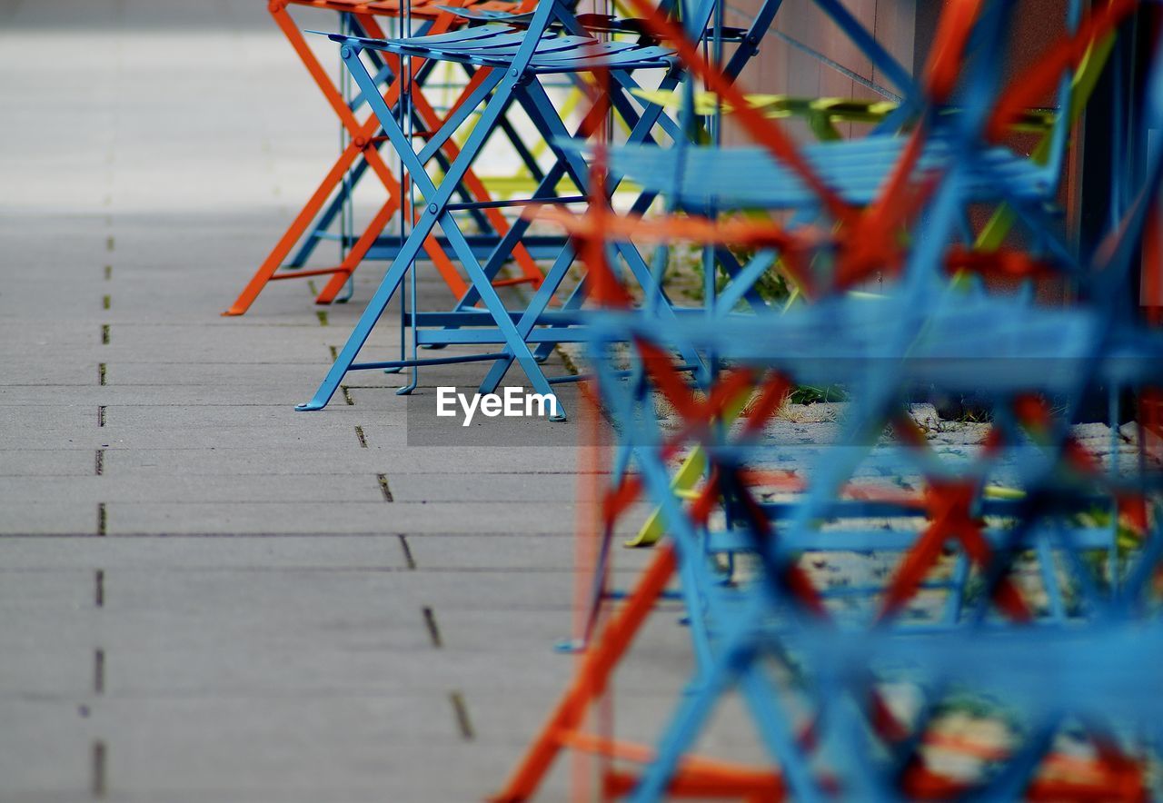 Close-up of chairs on sidewalk