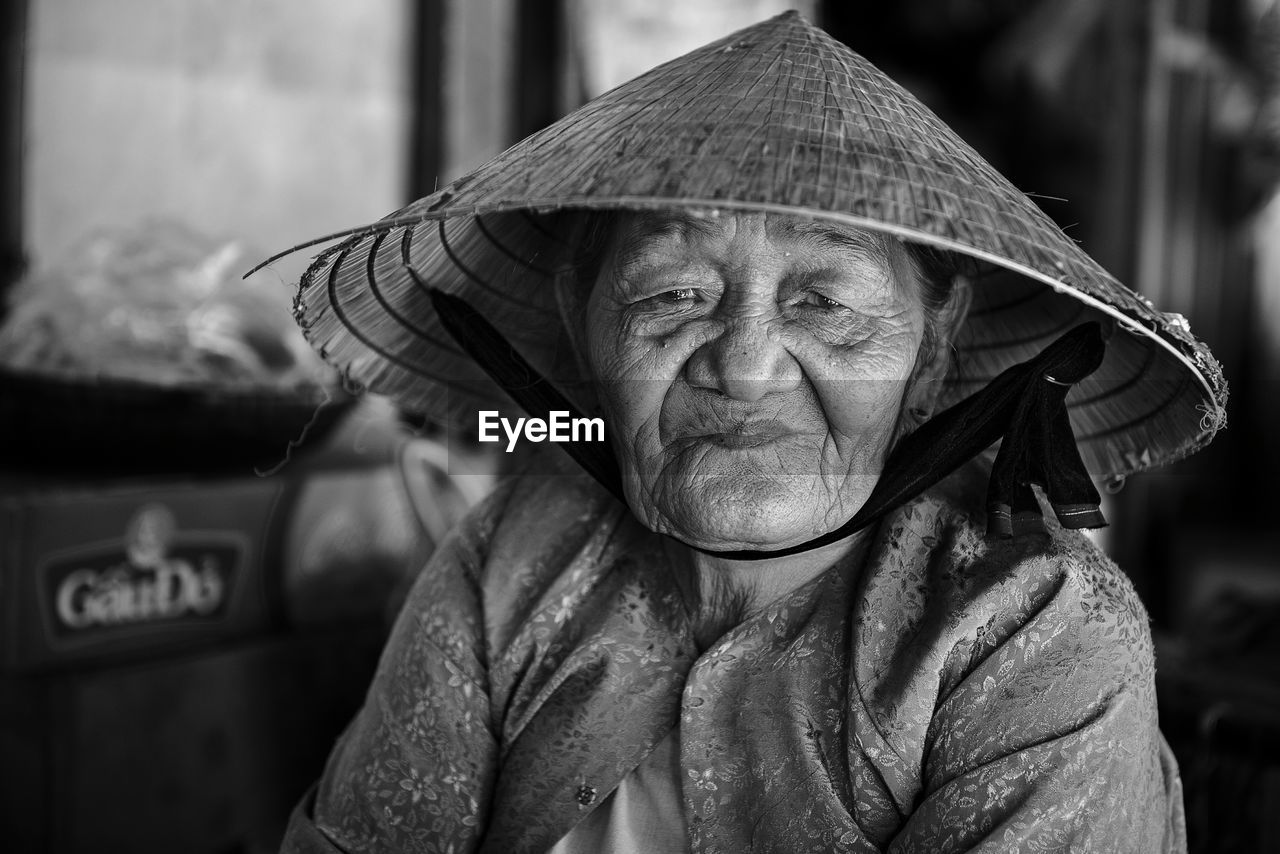 Close-up portrait of woman wearing asian style conical hat