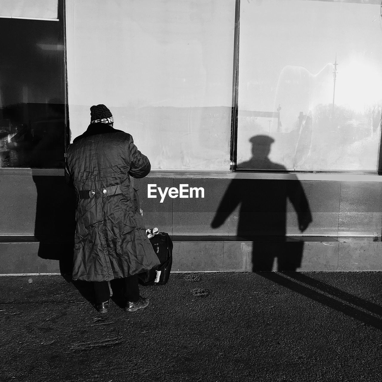 REAR VIEW OF MAN AND WOMAN WALKING ON ROAD