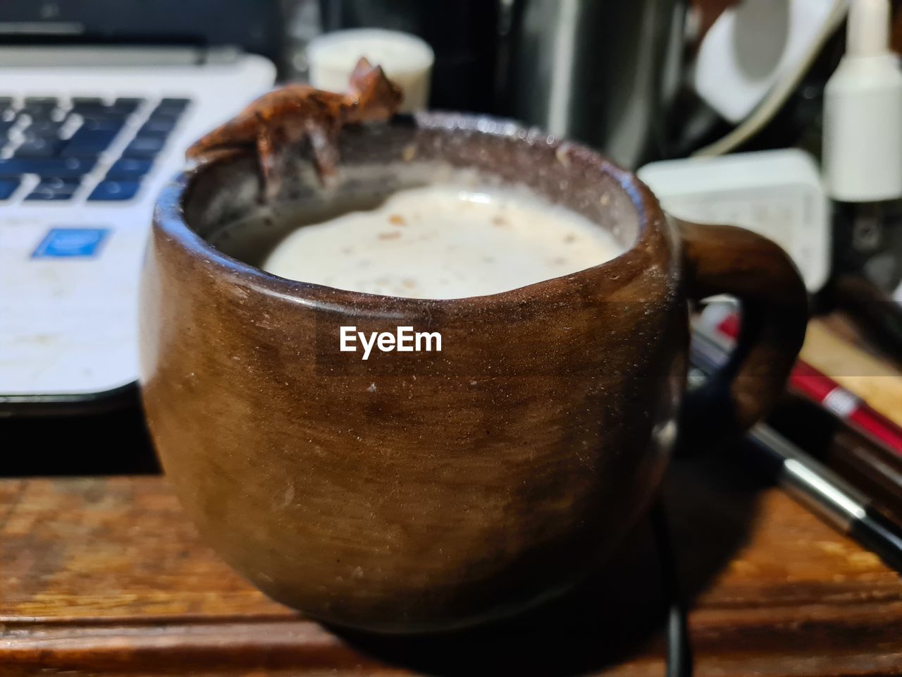 food and drink, drink, indoors, refreshment, coffee, food, close-up, table, household equipment, freshness, still life, cup, mug, no people, coffee cup, focus on foreground, business, hot drink, appliance, kitchen utensil, wood, meal, dish, heat, frothy drink, selective focus, laptop