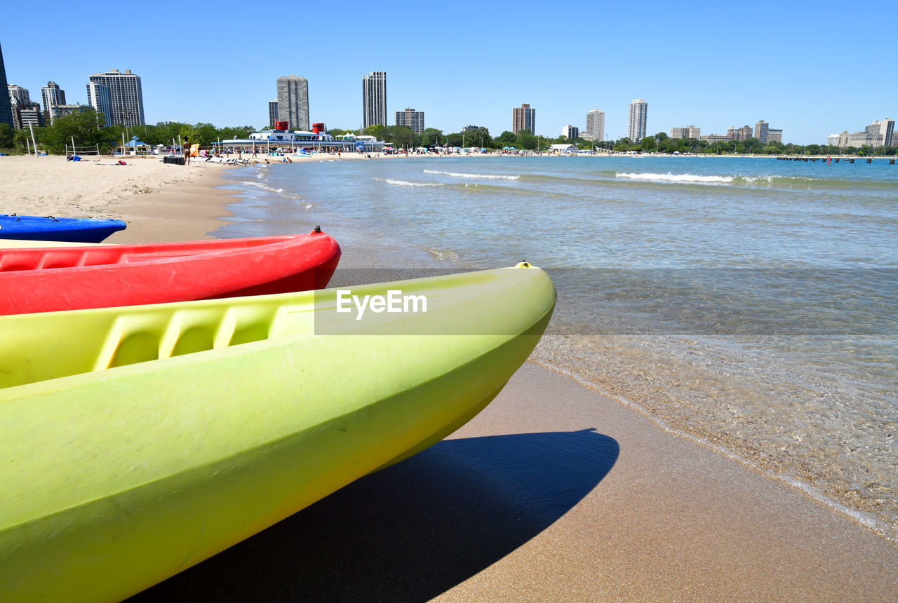 Kayaks on the beach along the city shore