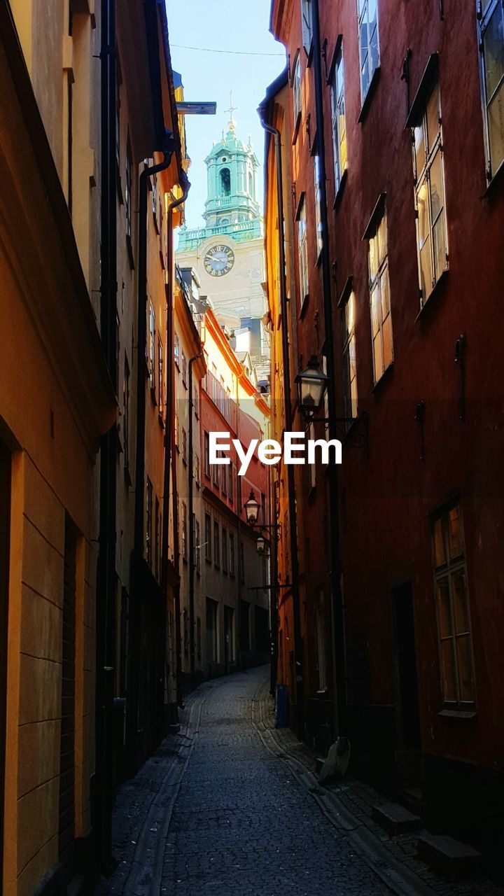 NARROW ALLEY WITH BUILDINGS IN BACKGROUND