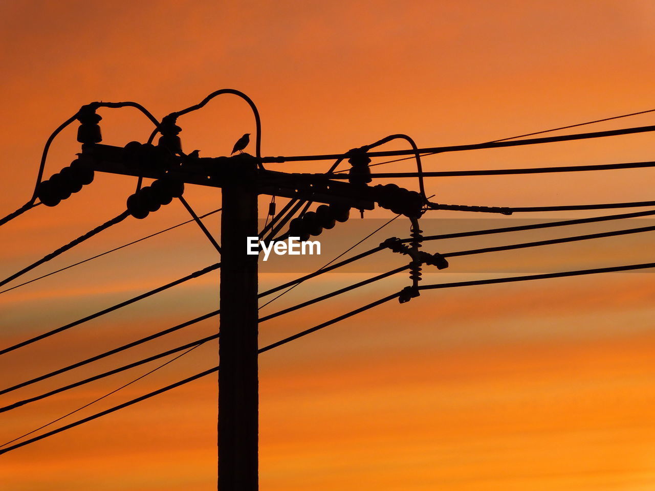 LOW ANGLE VIEW OF SILHOUETTE ELECTRICITY PYLON AGAINST SUNSET SKY