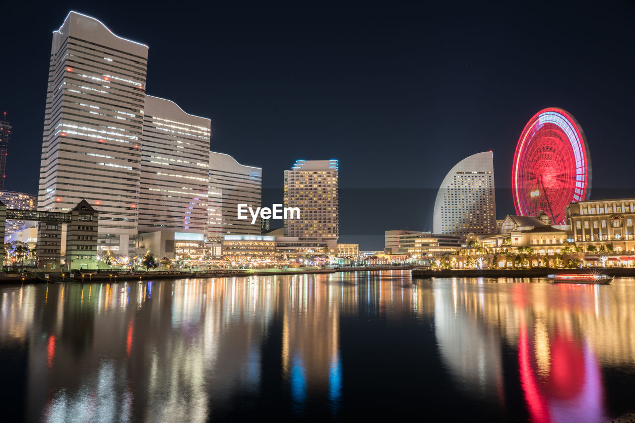 RIVER BY ILLUMINATED BUILDINGS AGAINST SKY AT NIGHT