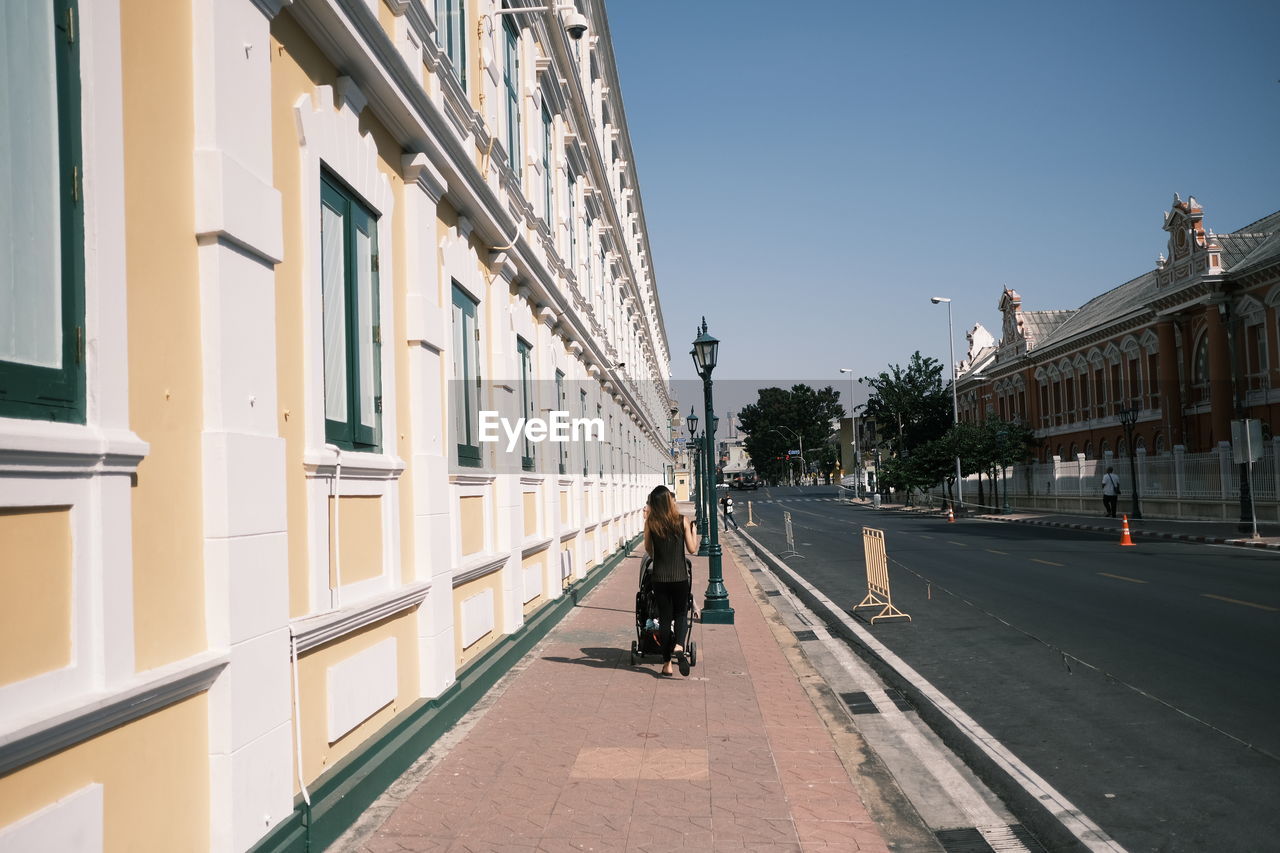 Man walking on street amidst buildings in city