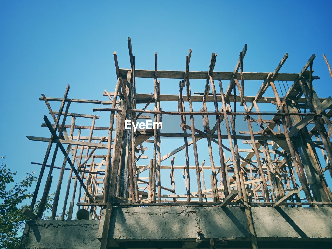 LOW ANGLE VIEW OF CRANE AGAINST BLUE SKY