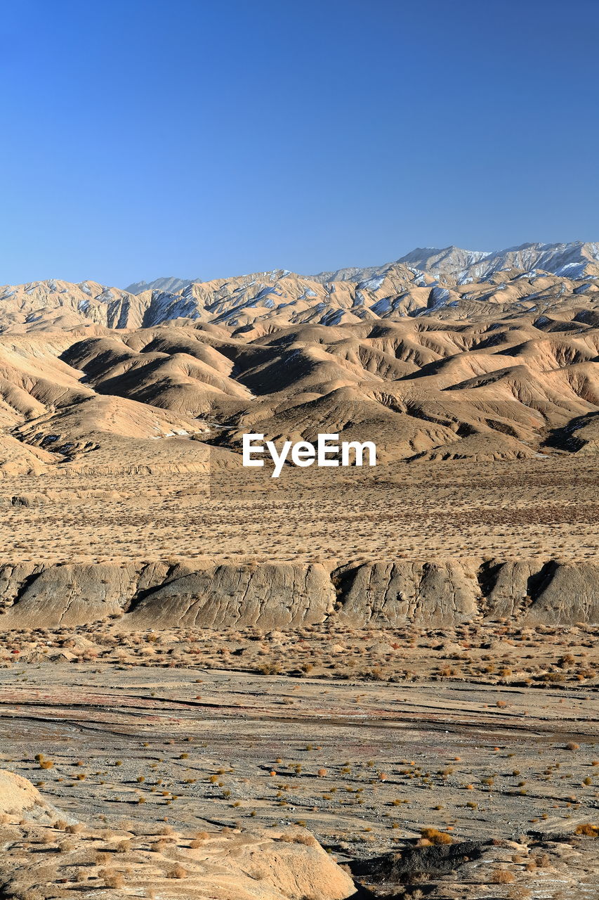 Scenic view of desert against clear blue sky