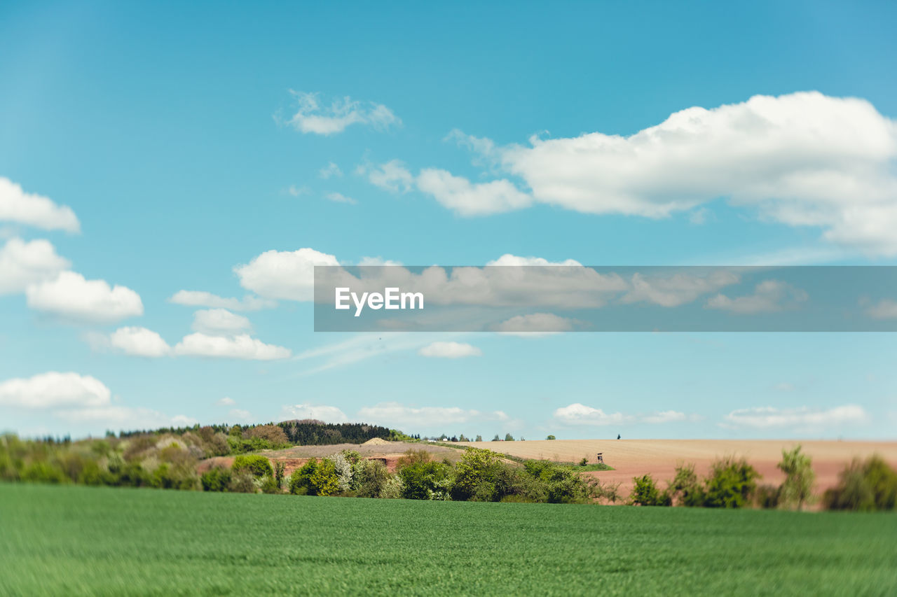 Scenic view of grassy field against cloudy sky