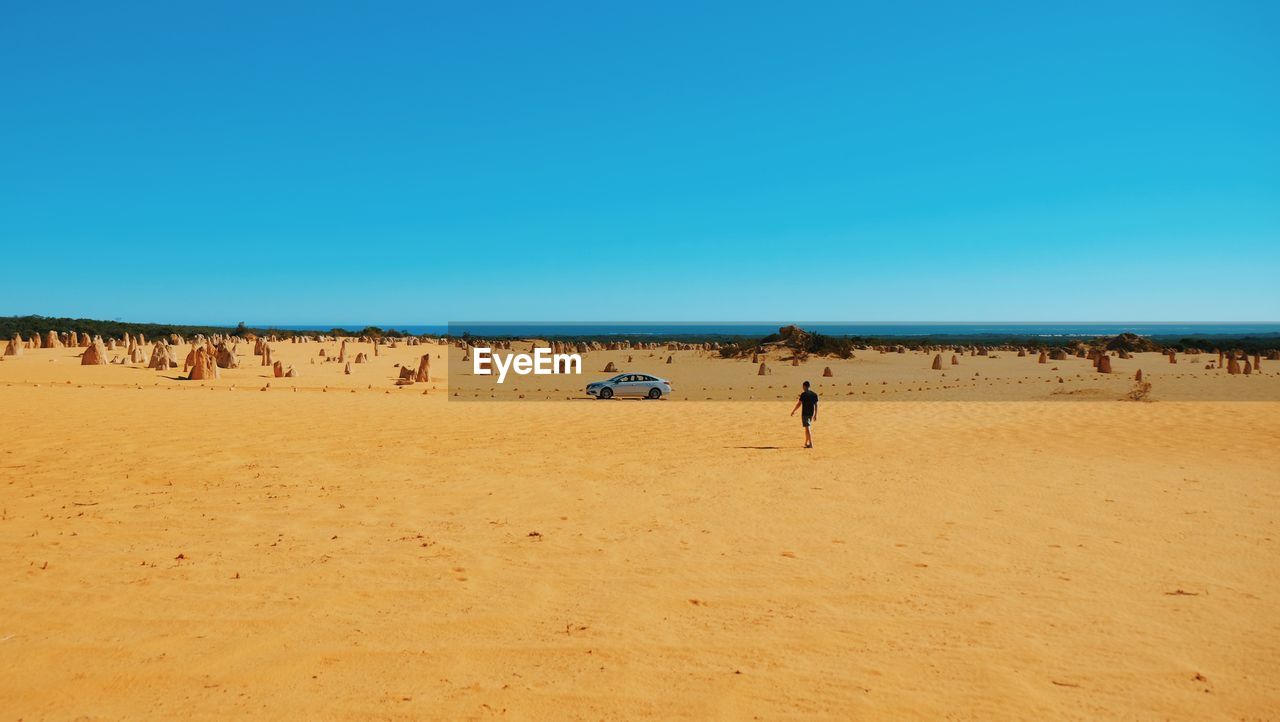 Panoramic view of beach against clear blue sky