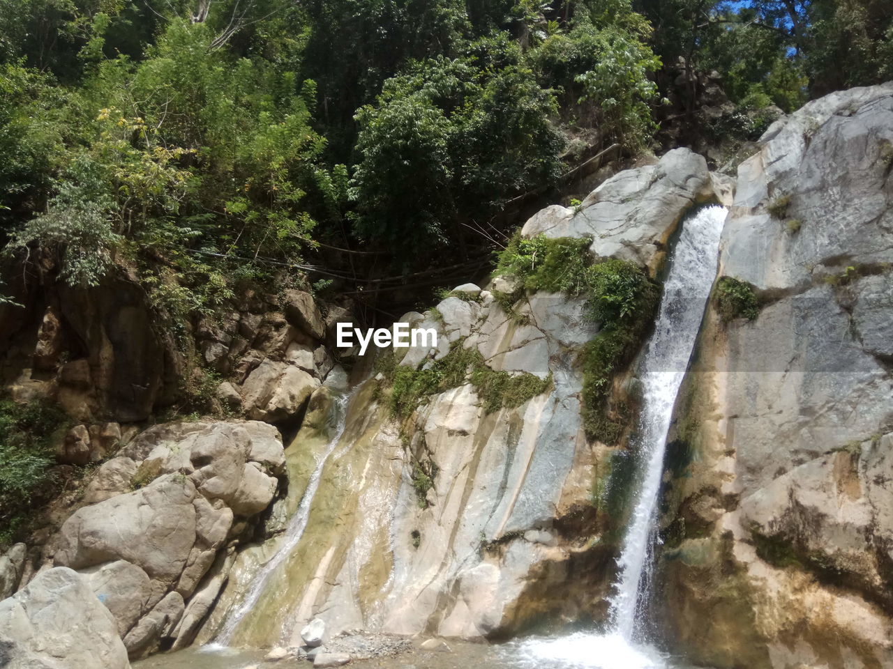 SCENIC VIEW OF WATERFALL IN MOUNTAINS