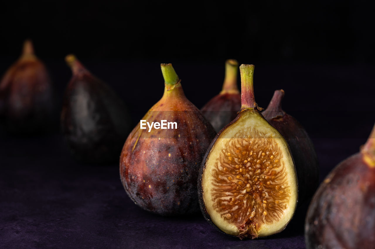 Close-up of figs on table against black background