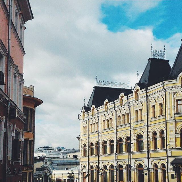 LOW ANGLE VIEW OF BUILDINGS AGAINST CLOUDY SKY