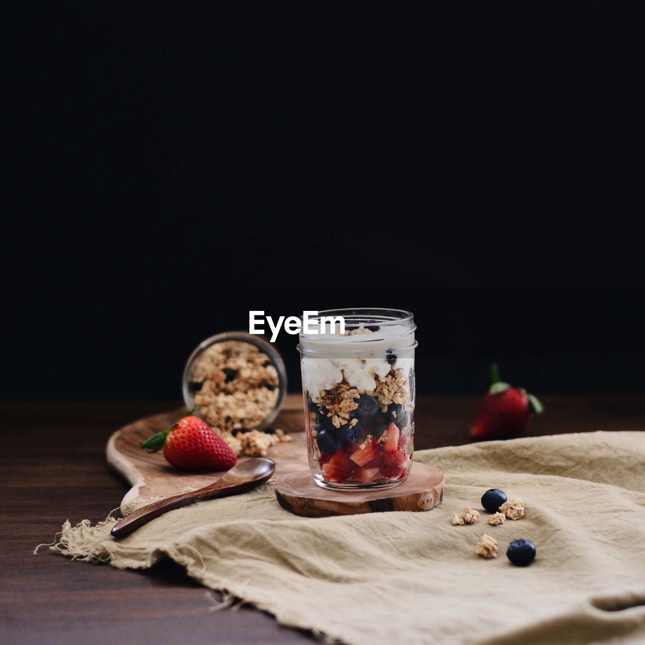 Muesli in jar on table against black background