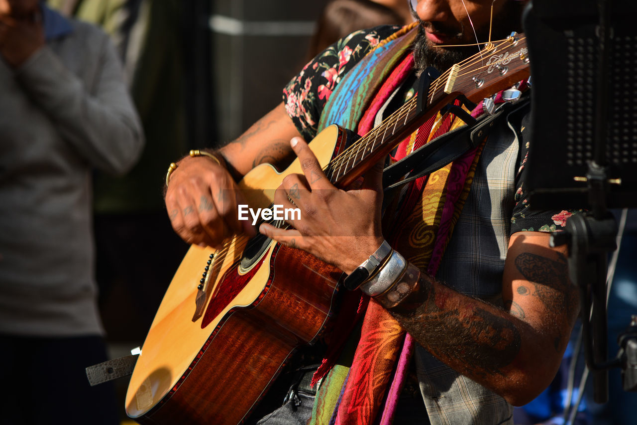 MIDSECTION OF MAN PLAYING GUITAR