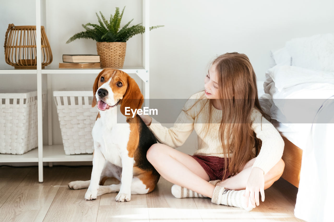 WOMAN SITTING WITH DOG AT HOME