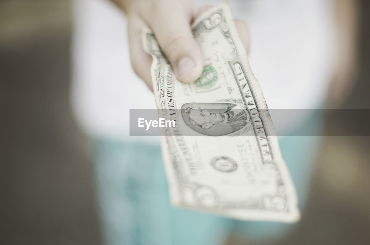 Close-up of teenager holding a dollar bill