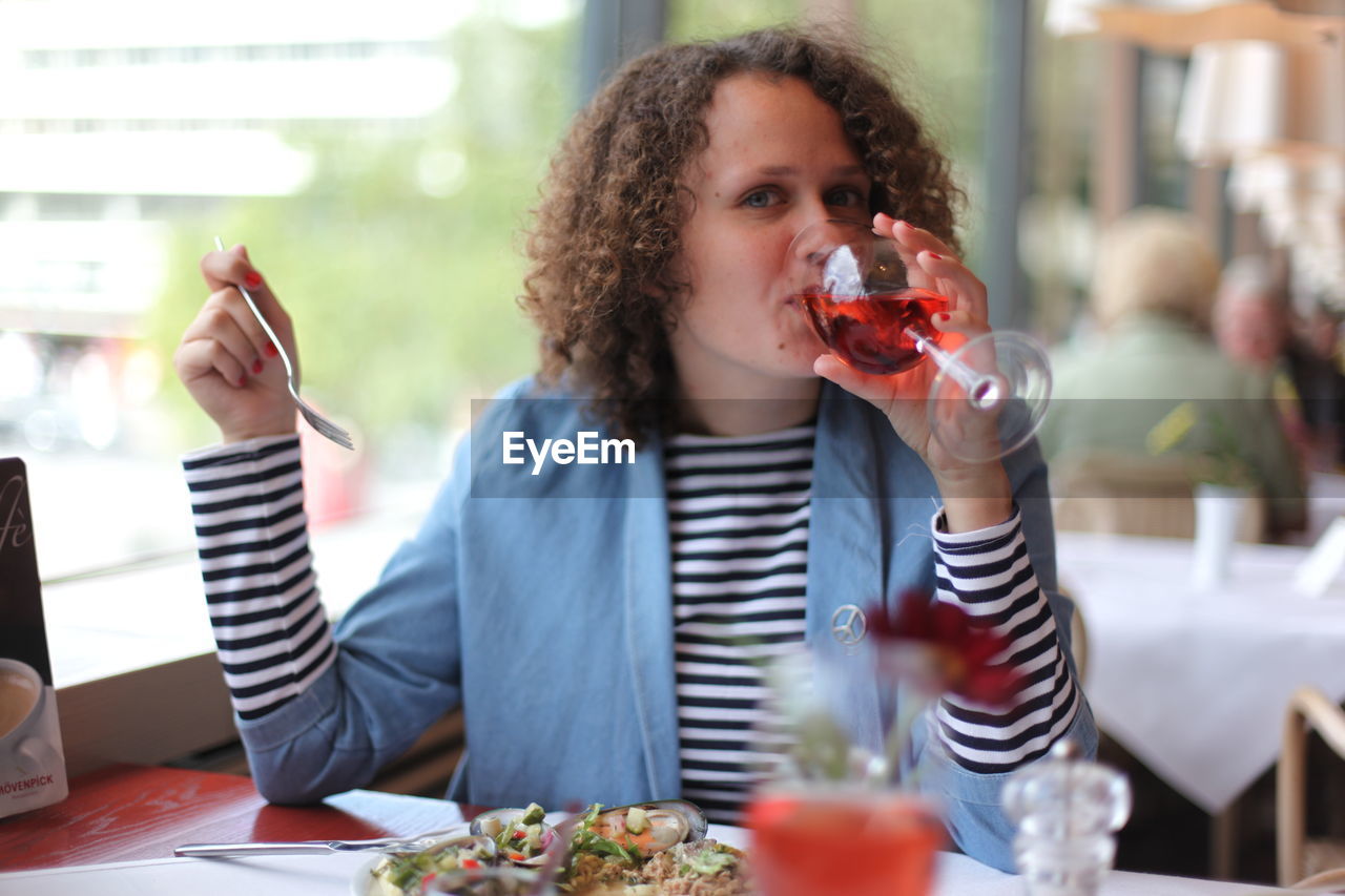 Portrait of woman drinking wine at restaurant