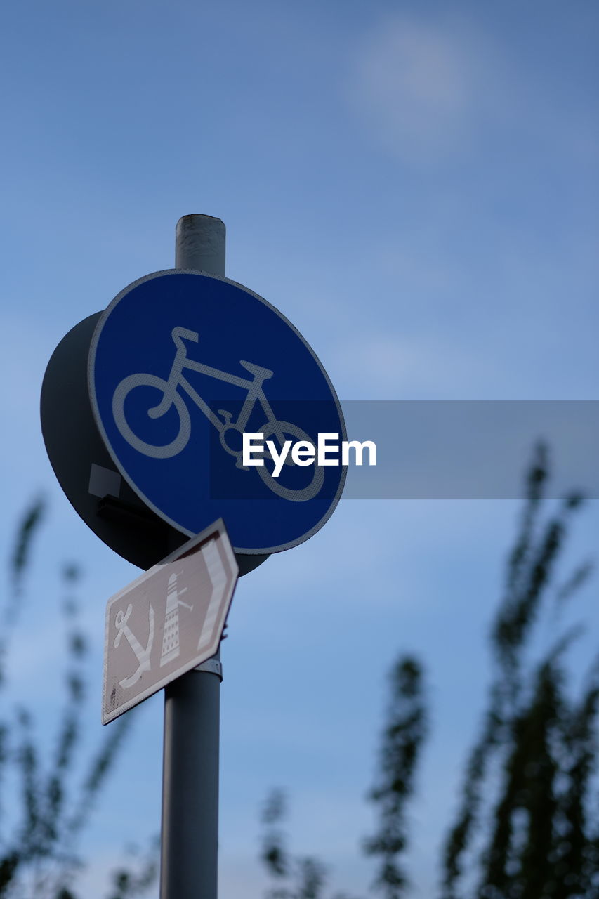 Low angle view of information sign against sky