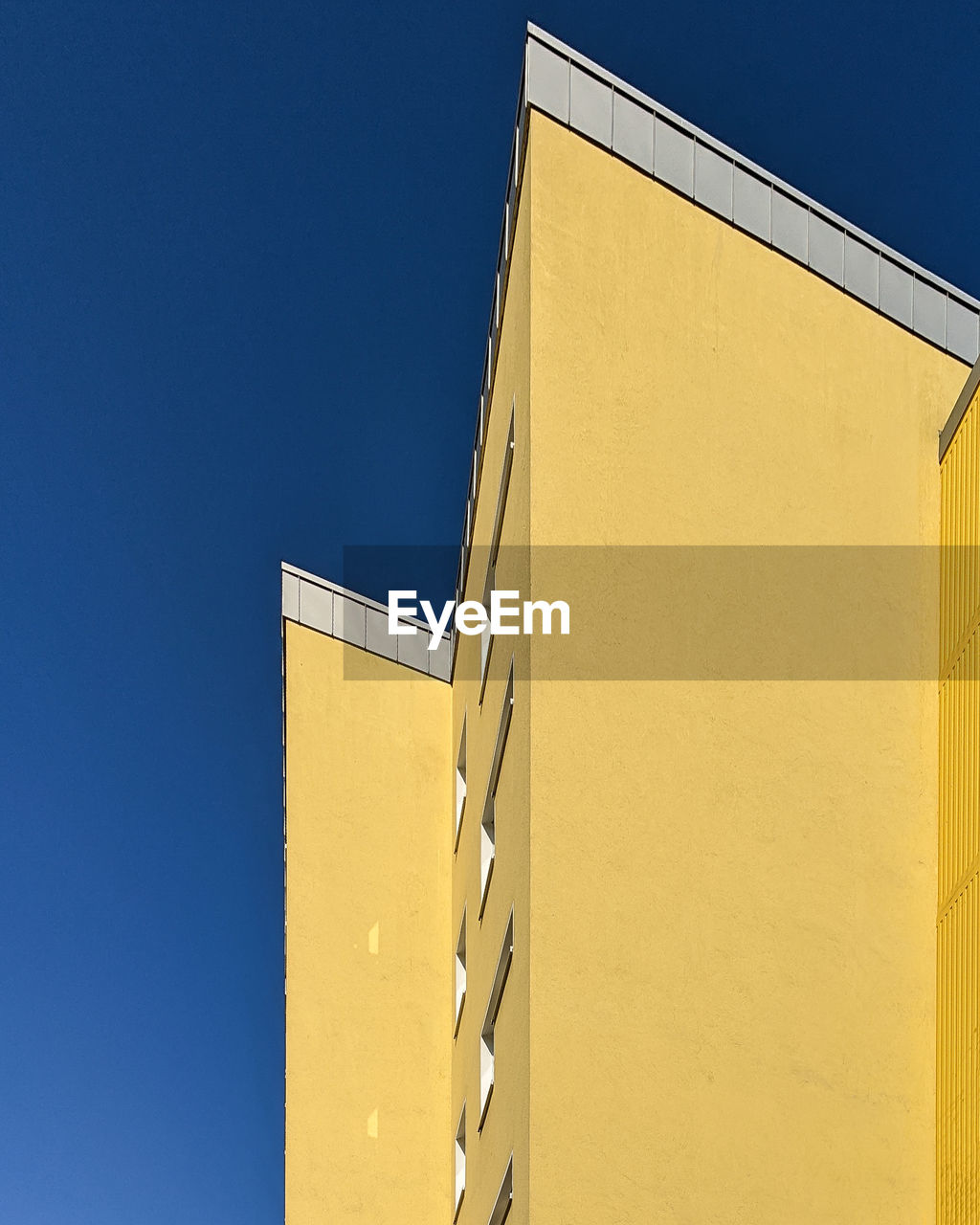 Low angle view of building against clear blue sky