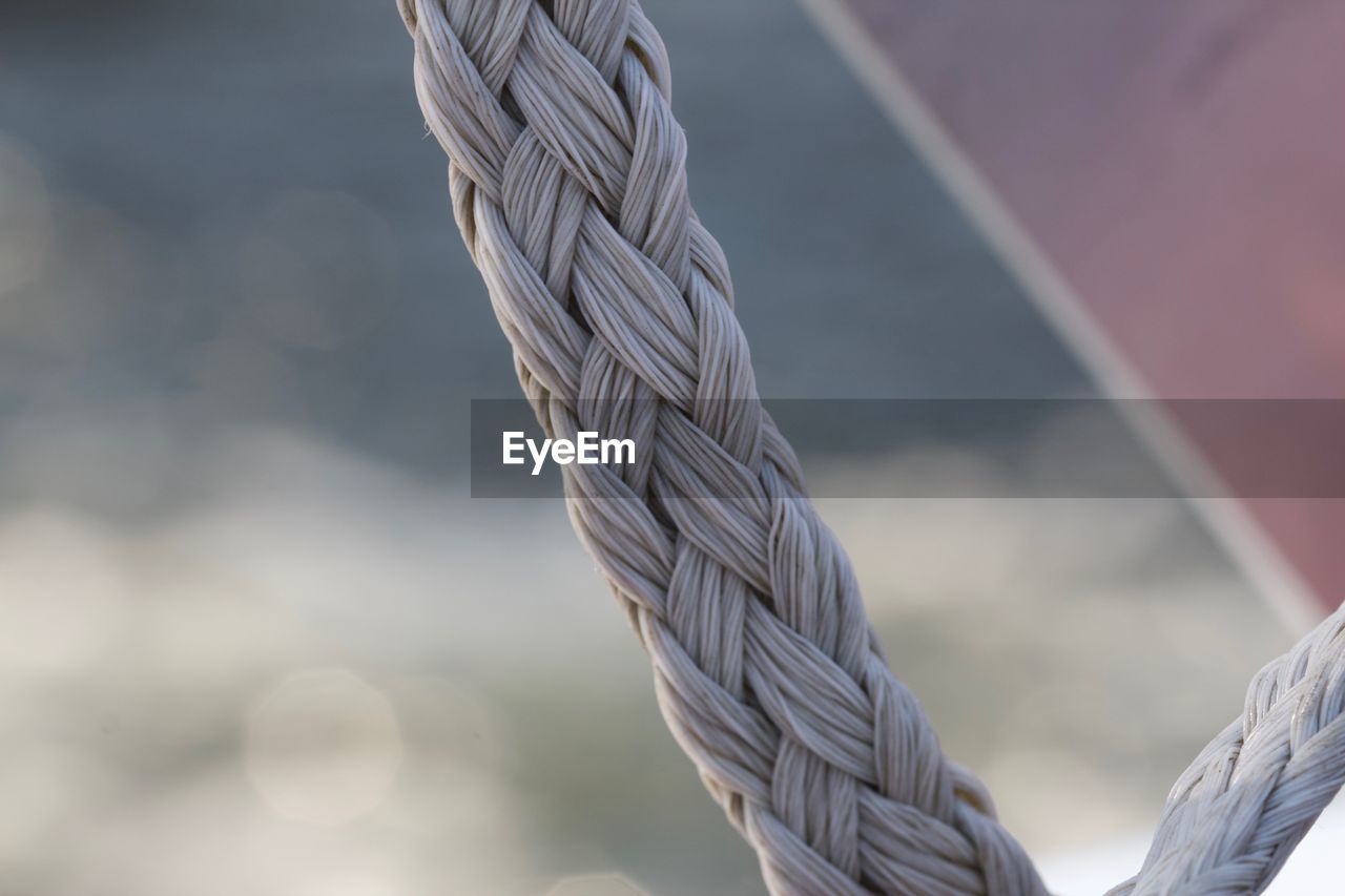 CLOSE-UP OF ROPE TIED ON METAL