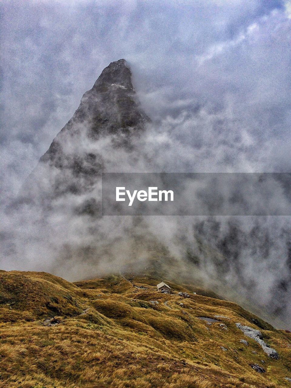 Scenic view of mountains against cloudy sky