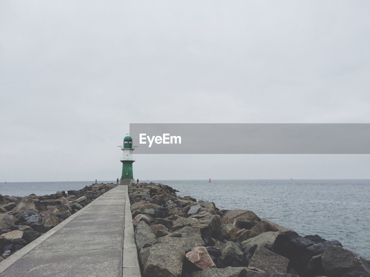 Distance shot of lighthouse against calm sea