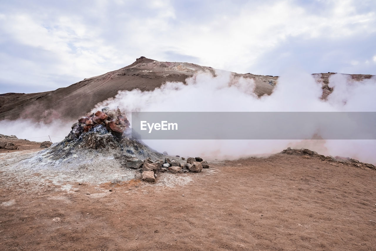 View of steam emitting from fumarole in geothermal area of hverir against sky