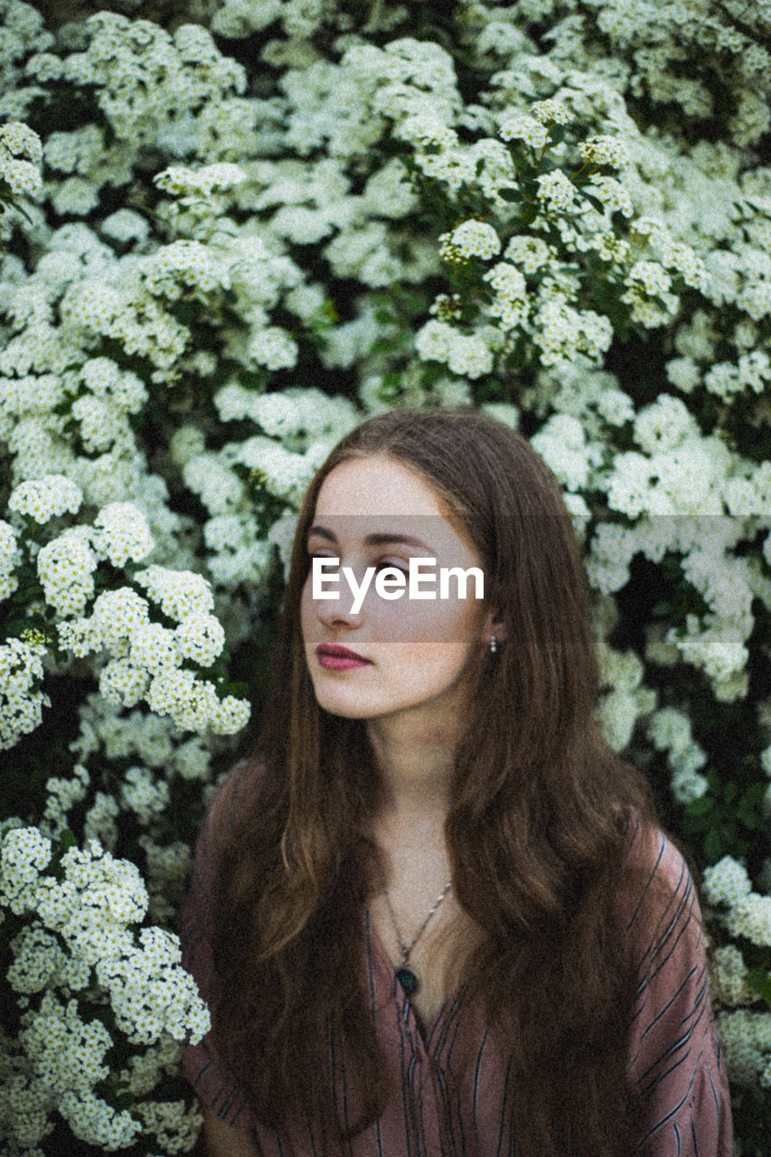 Portrait of young woman looking at plants