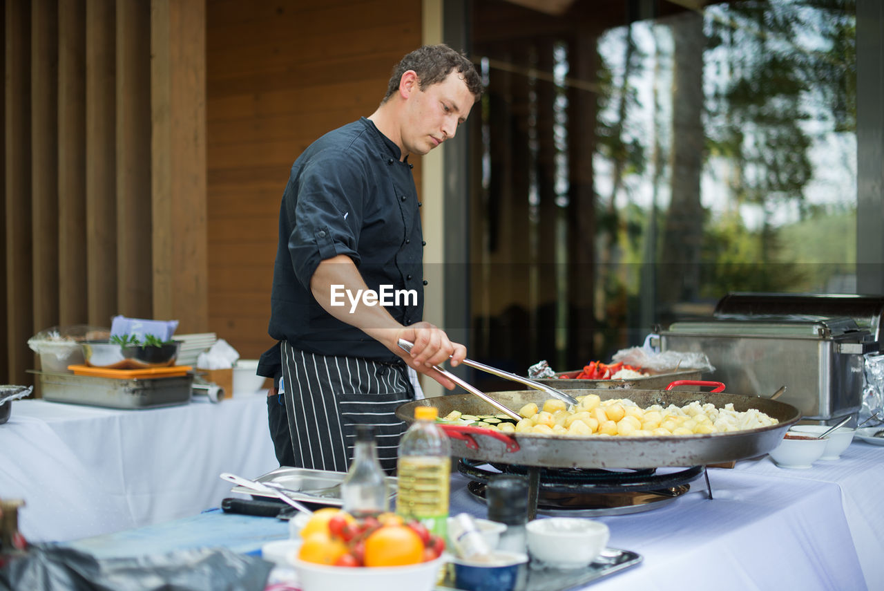 Man preparing food against trees