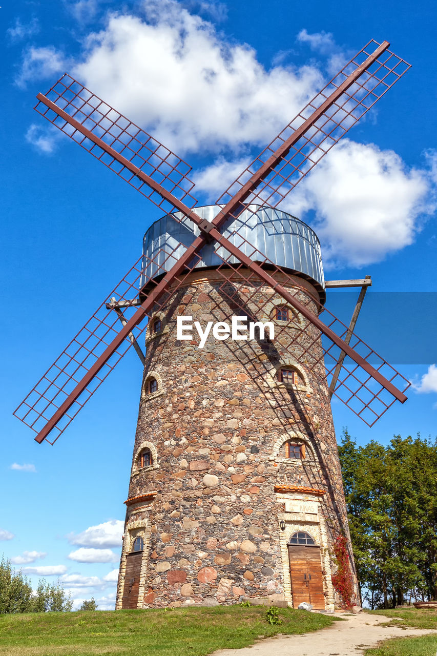 low angle view of windmill on field against sky