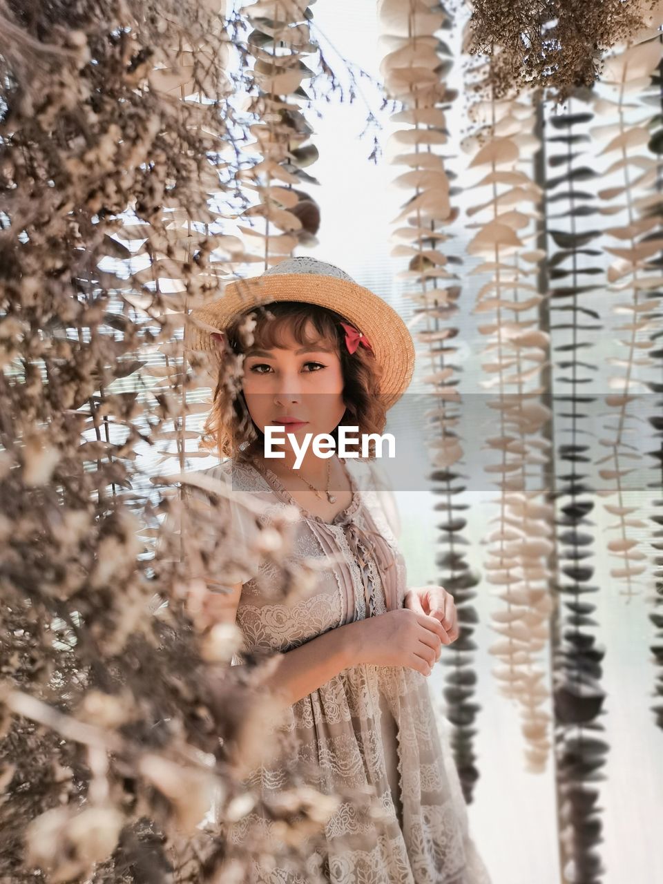 Portrait of woman standing by tree during winter