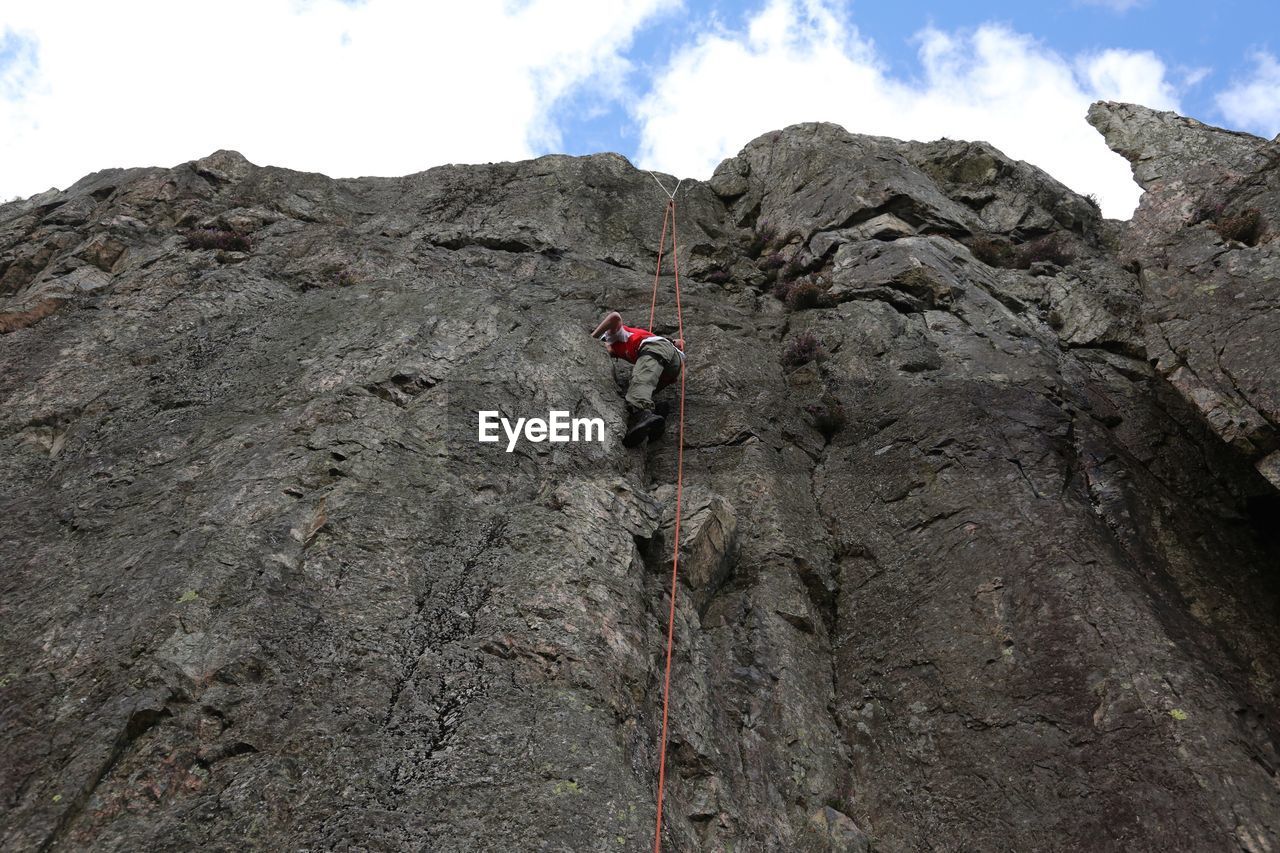 Low angle view of person climbing mountain