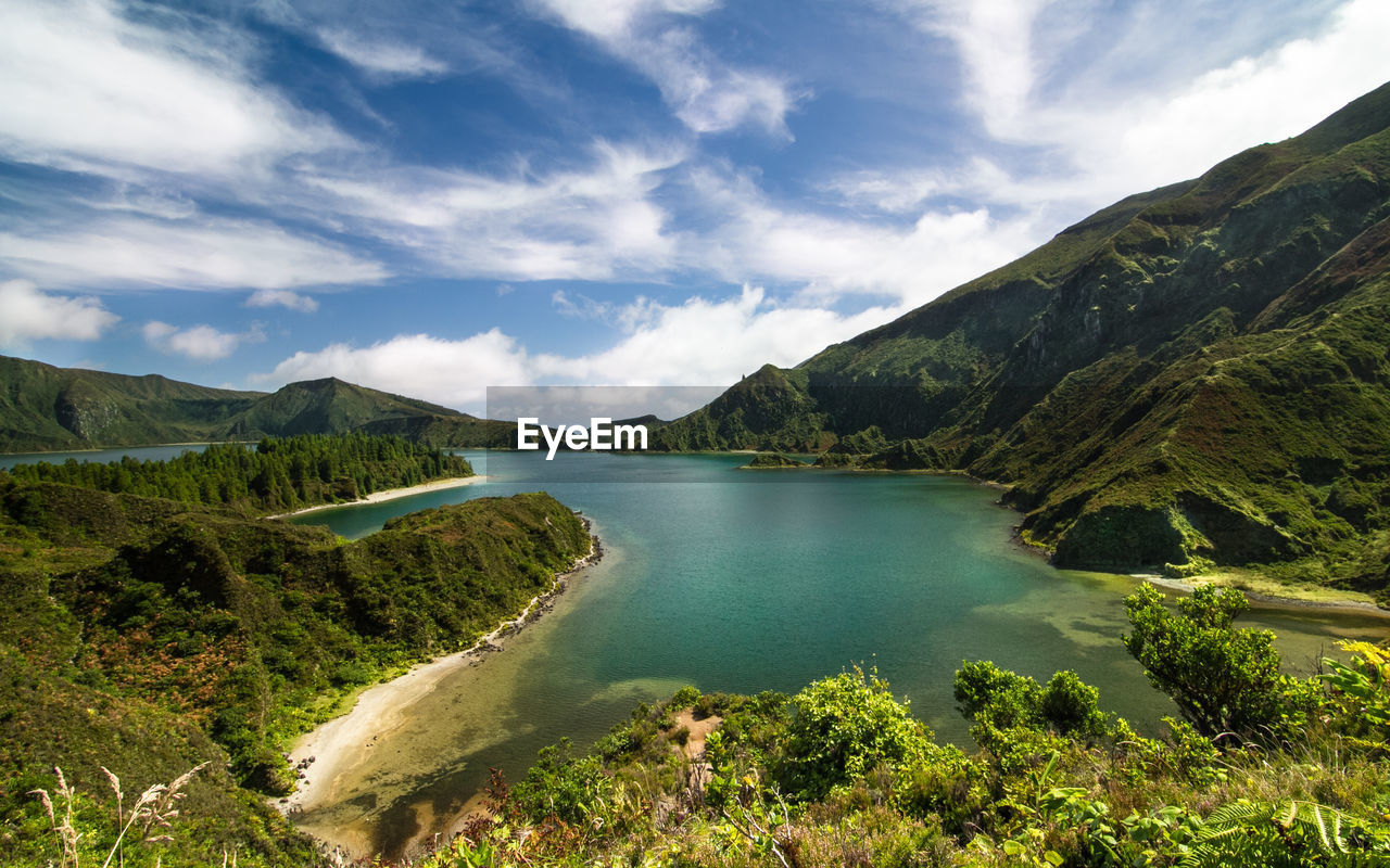 Scenic view of lagoa do fogo amidst mountains against sky