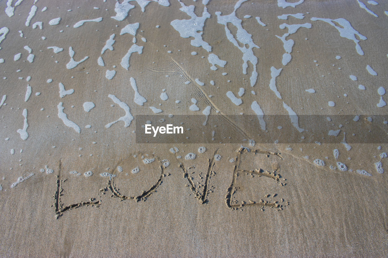 High angle view of text on sand at beach