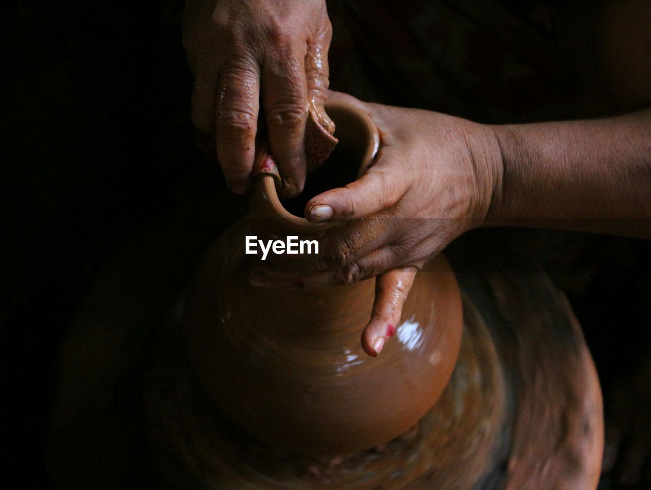 Cropped hands of man molding pot in workshop