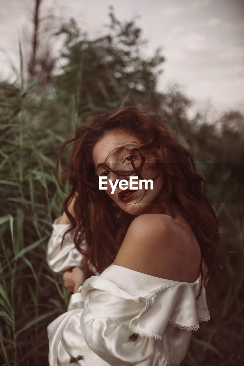 PORTRAIT OF A BEAUTIFUL YOUNG WOMAN IN THE FIELD