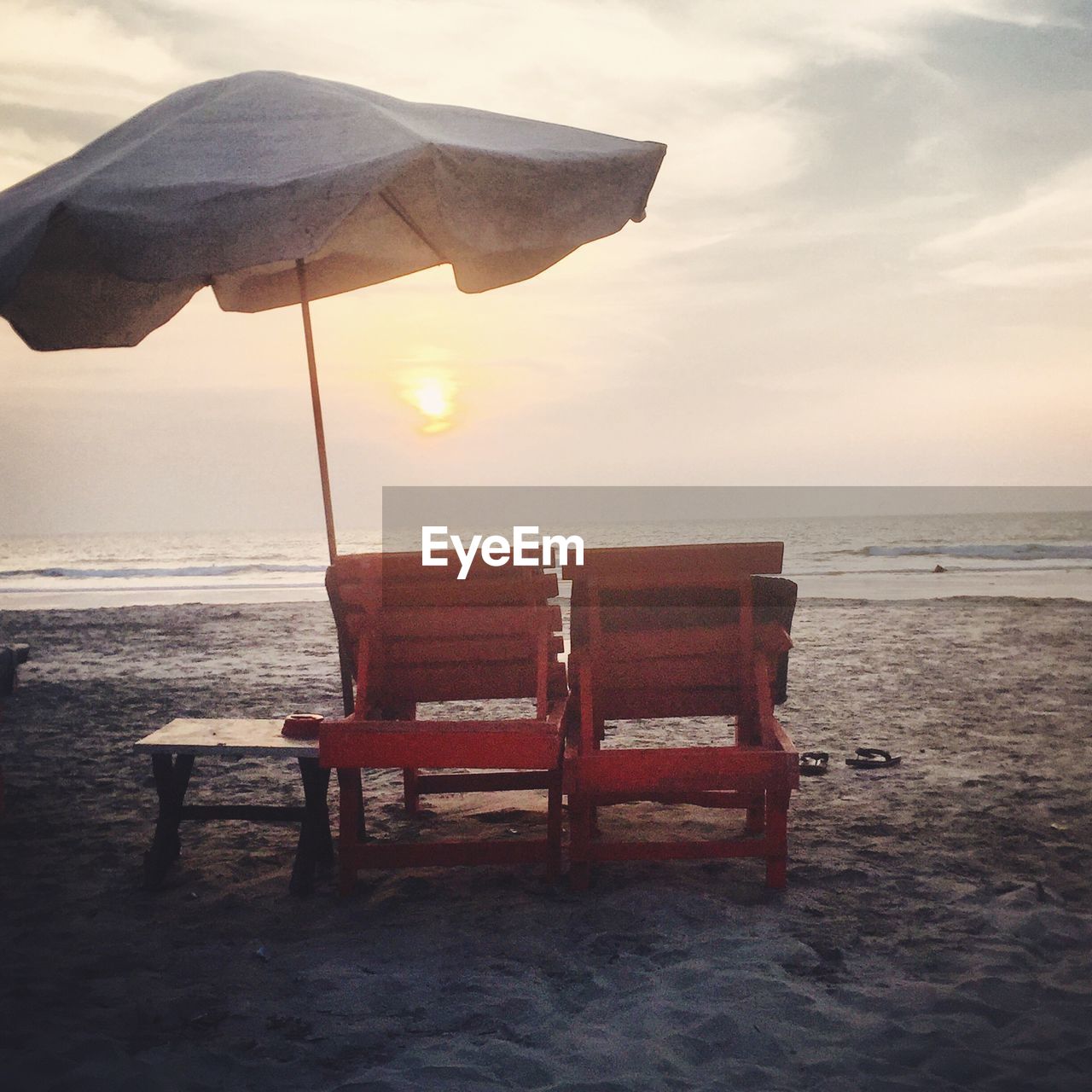 CHAIR ON BEACH AGAINST SKY AT SUNSET