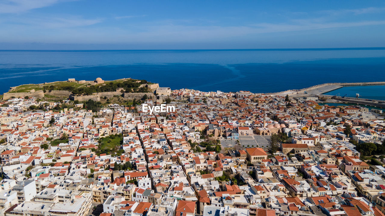 High angle view of townscape by sea against sky in rethymno, crete, greece