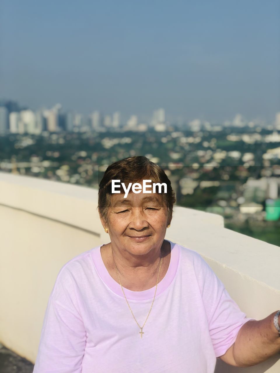 Portrait of old woman looking away against sky