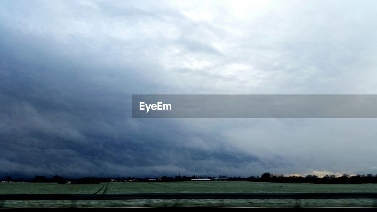 Scenic view of field against cloudy sky