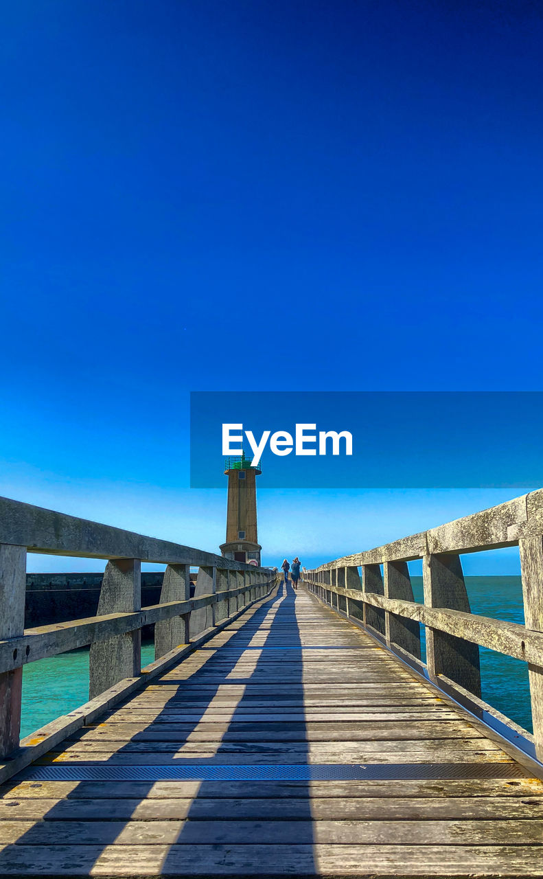 View of pier over sea against blue sky