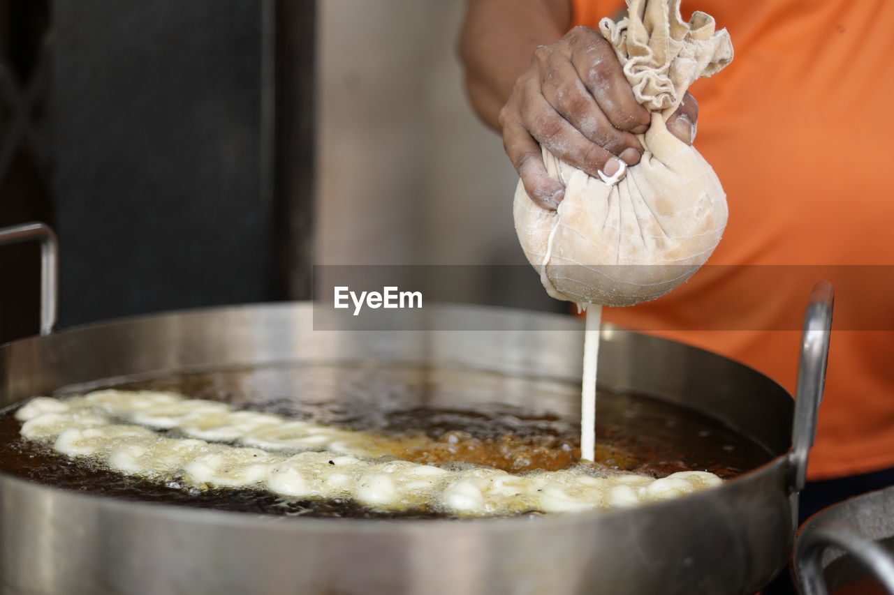 Close-up of hand making jalebi