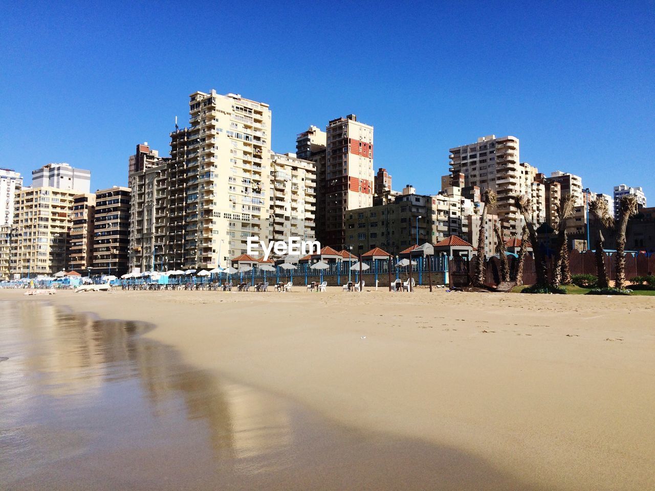 Low angle view of buildings and beach against clear sky