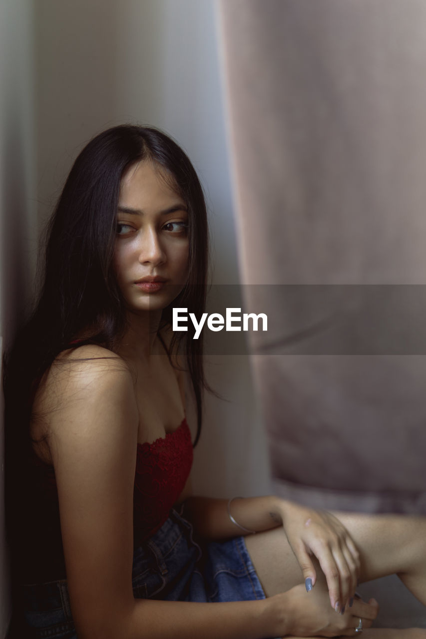 Portrait of a beautiful young woman sitting at home