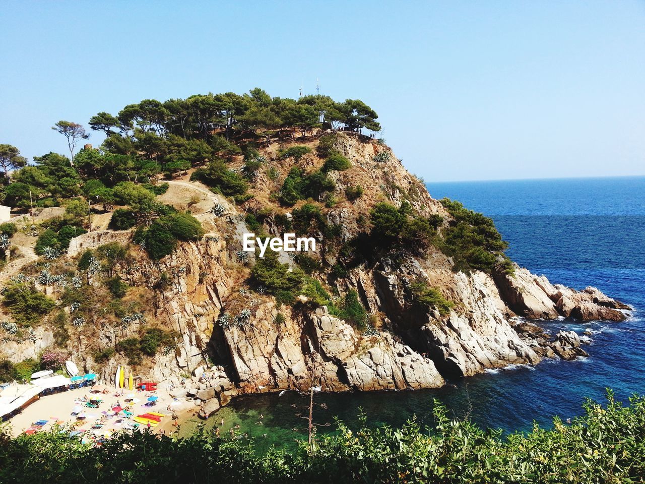 Rock formations by sea against clear sky